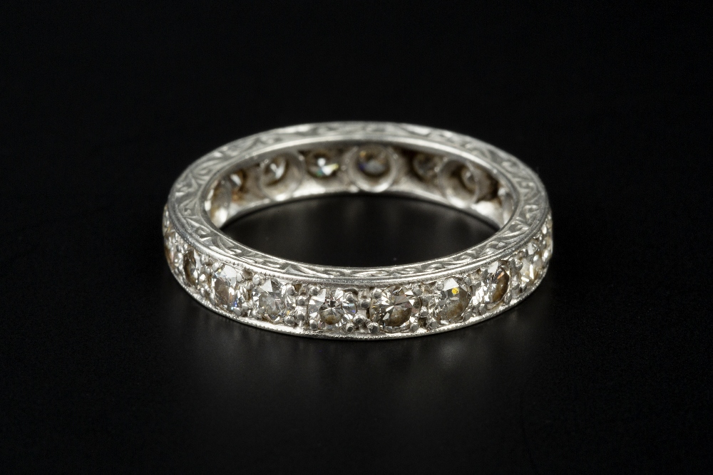 A DIAMOND FULL HOOP ETERNITY RING, the scroll engraved hoop set throughout with round brilliant