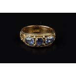 A SAPPHIRE THREE STONE RING, the oval and cushion-shaped mixed-cut sapphires claw set to a foliate