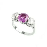 A RUBY AND DIAMOND THREE STONE RING, the cushion-shaped mixed-cut ruby in claw setting, between