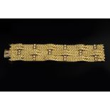 A DIAMOND SET BRACELET BY KUTCHINSKY, comprising six articulated rows of textured chevron links,