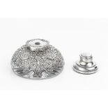 A LATE VICTORIAN SILVER MOUNTED GLASS INKWELL, of shallow, domed form, pierced and repoussé