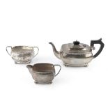 A SILVER THREE PIECE TEA SERVICE, of bowed rectangular form with gadrooned borders, the teapot