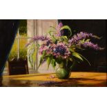 MATT GROGAN (b.1947) Still life, a green jug with mixed flowers upon a table surface in an interior,