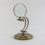 A reproduction brassed table magnifier,