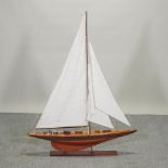 A French wooden model of a pond yacht, with sails and rigging, on a wooden stand,