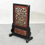 An early 20th century Chinese carved fire screen,