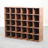 A pine wall shelf, containing an arrangement of pigeon holes,