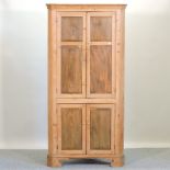 An antique pine standing corner cabinet,