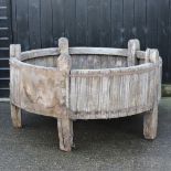 A large circular wooden and iron bound feeding trough,
