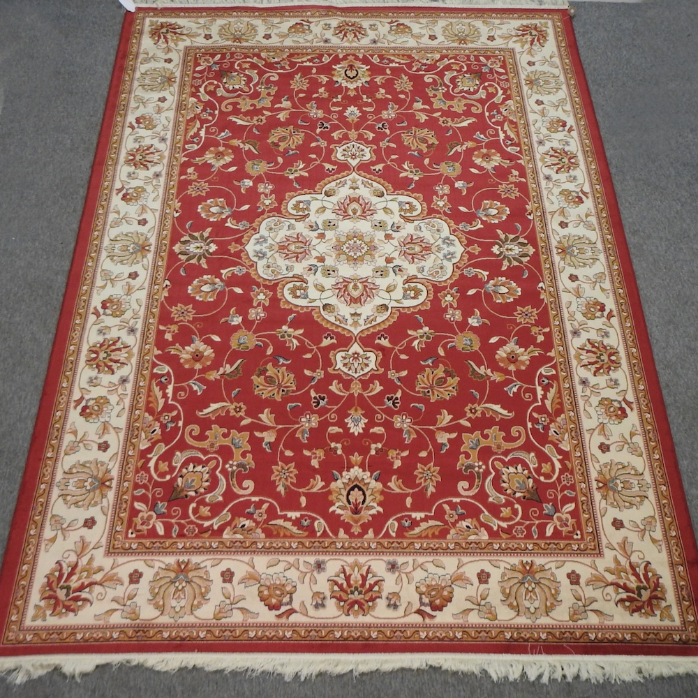 A Keshan style carpet, with floral design on red ground,