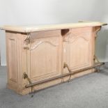 A large American carved wooden bar, with a brass rail,