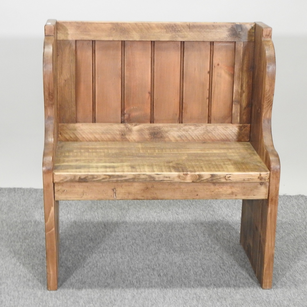 A pine pew, of small proportions,