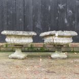 A pair of reconstituted stone pedestal planters,