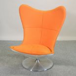 A 1970's white fibreglass swivel chair, with orange upholstery,