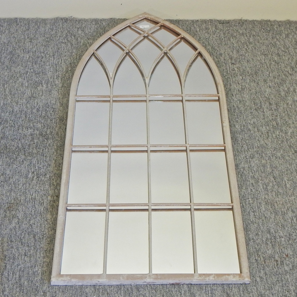 An arched outdoor wall mirror,