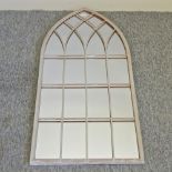An arched outdoor wall mirror,