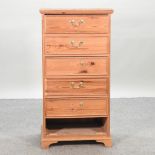 A narrow pine chest of drawers,