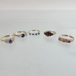 A 9 carat gold and garnet set ring, together with two 9 carat gold sapphire rings,