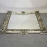 A large ornate silver framed wall mirror,