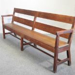 An early 20th century pitch pine bench, with loose cushion,