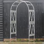 A white painted metal garden arch,