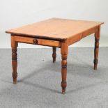 A Victorian pine kitchen table, containing a single drawer, on turned legs,
