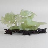 A jade coloured hardstone carving of birds, mounted on a wooden plinth,