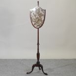 A Victorian mahogany shield shaped pole screen,