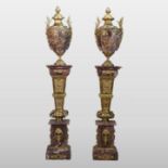 A pair of large and ornate rouge marble urns, each of Grecian style,