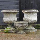 A pair of reconstituted stone pedestal planters,