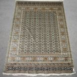 A Bokhara style carpet, with geometric design on green ground,