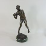 A bronze figure of an athlete, on a marble base,