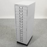 A set of narrow metal filing drawers,