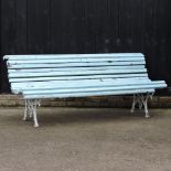 A blue painted cast iron garden bench, with a slatted wooden seat,