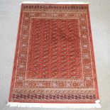 A Bokhara carpet, with all over design on a red ground,