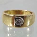 An 18 carat gold band, set with a single diamond,