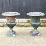 A pair of antique style cast iron urns,