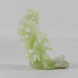 A jade coloured hardstone carving of bird in a tree,