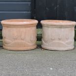 A pair of circular terracotta planters,