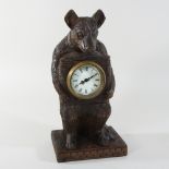 A black forest style mantel clock, in the form of a bear,