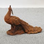 A rusted metal garden model of a peacock,