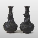 A pair of Chinese bronze vases, each of bottle shape, each relief decorated with a dragon,