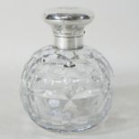 An early 20th century cut glass perfume bottle, with a silver hinged cover, London 1929,
