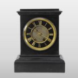 A large 19th century black slate mantel clock, the dial showing Roman numerals,