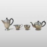 An early 20th century silver four piece tea service, of circular half faceted form,
