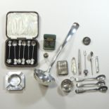 A collection of decorative silver items, to include three mustard spoons, a wine taster,