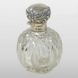 A Victorian silver mounted cut glass scent bottle, the hinged lid embossed with flowers,