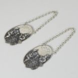 A pair of silver decanter labels, each relief decorated with cherubs, inscribed PORT and WHISKY,