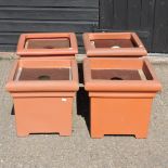 A set of four terracotta effect garden pots,