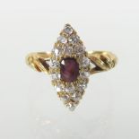 An 18 carat gold ruby and diamond cluster ring, of elliptical shape,
